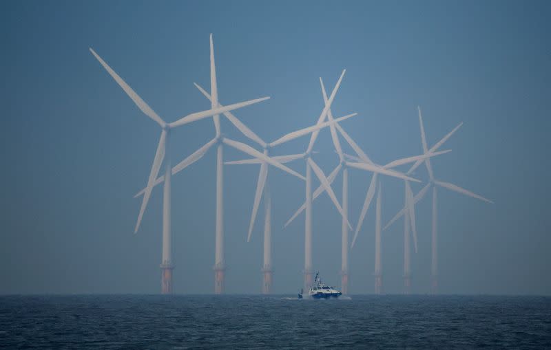 FILE PHOTO: A survey vessel sails past wind turbines at the Burbo Bank offshore wind farm near New Brighton