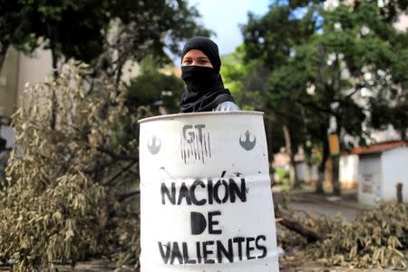 A demonstrator holds a makeshift shield that reads "Nation of the brave" during a strike called to protest against Venezuelan President Nicolas Maduro's government in Caracas, Venezuela, July 26, 2017. REUTERS/Marco Bello