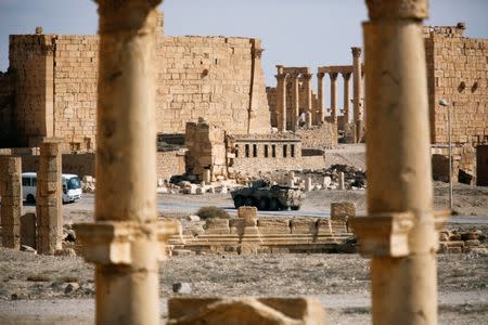 A Russian military vehicle drives near ruins in the historic city of Palmyra, Syria March 4, 2017. REUTERS/Omar Sanadiki