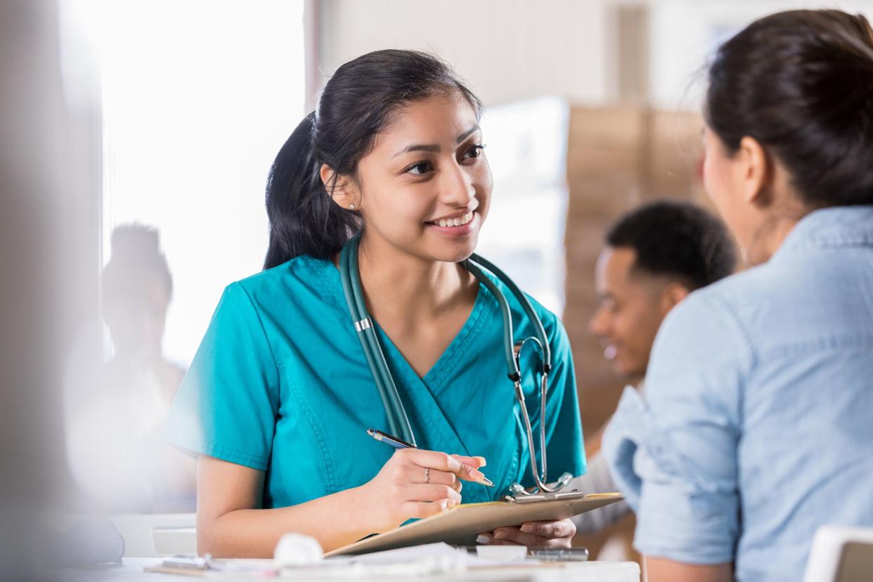 attentive young female nurse talks with female patient