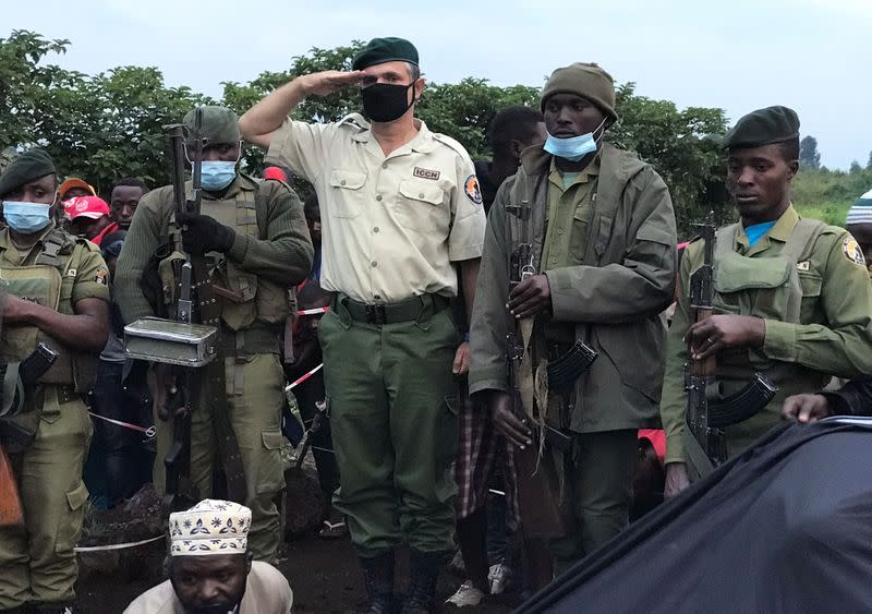 Virunga National Park Rangers and Park director Emmanuel Demerode salutes as they attend the burial of Burhani Abdou Surumwe in Goma