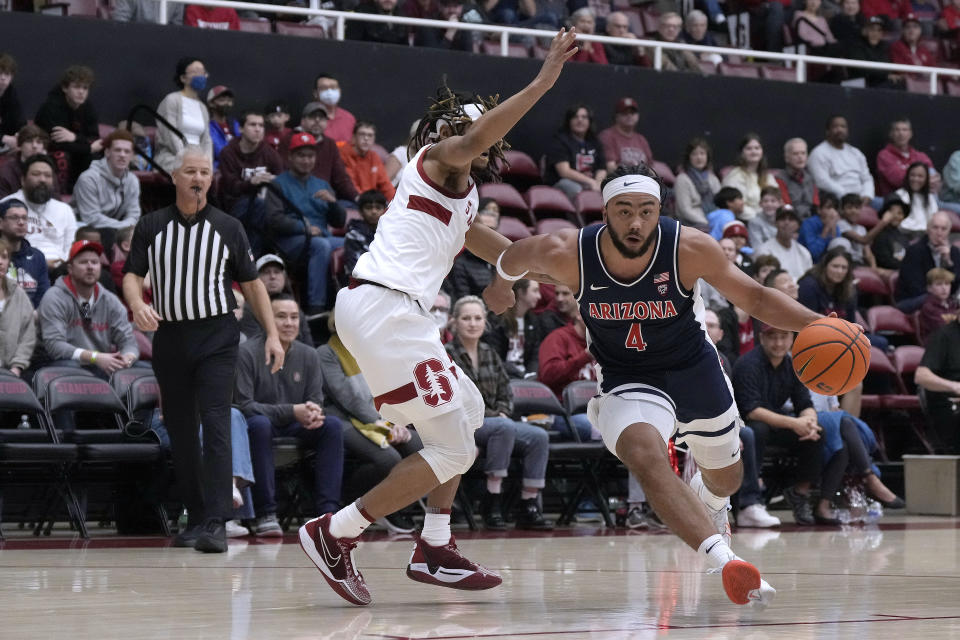 Arizona guard Kylan Boswell (4) dribbles around Stanford guard Kanaan Carlyle, left, during the first half of an NCAA college basketball game, Sunday, Dec. 31, 2023, in Stanford, Calif. (AP Photo/Tony Avelar)