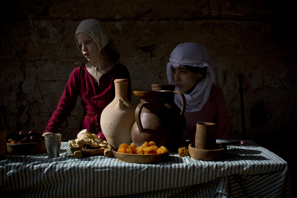 <p>Israeli members of knights club, a historical reenactment group, wear medieval costumes as they eat breakfast at their camp before marching 10 kilometers at the Judaea desert between Jerusalem and the West Bank town of Jericho, March 11, 2016. Some 20 history buffs took part in the three-day experience modeled on medieval life between the 12th and 14th century. (Photo: Oded Balilty/AP) </p>