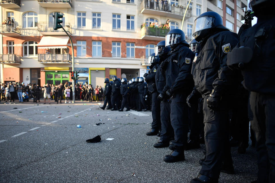 <p>Protesters look on as riot police stand guard during the “Welcome to Hell” protest march on July 6, 2017 in Hamburg, Germany. (Photo: Alexander Koerner/Getty Images) </p>