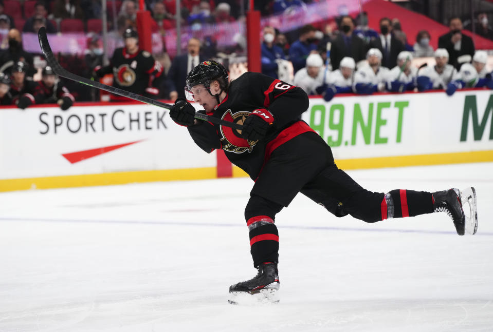 Ottawa Senators defenseman Lassi Thomson (60) takes a shot while taking on the Vancouver Canucks during the second period of an NHL hockey game, Wednesday, Dec.1, 2021 in Ottawa, Ontario. (Sean Kilpatrick/The Canadian Press via AP)