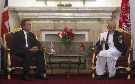 Afghanistan's President Ashraf Ghani (R) speaks next to Britain's Prime Minister David Cameron during their meeting at the presidential palace in Kabul October 3, 2014. REUTERS/Massoud Hossaini