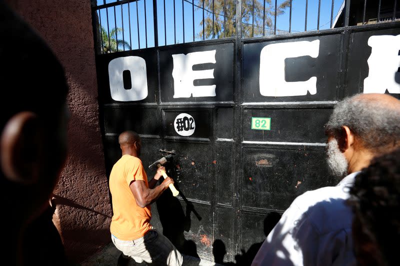 A man tries to open the gates of an orphanage after part of it was destroyed in a fire, in Port-au-Prince