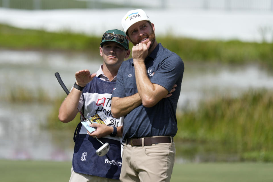 Chris Kirk, right, talks with his caddie Michael Cromie, left, on the 17th green during the second round of the Honda Classic golf tournament, Friday, Feb. 24, 2023, in Palm Beach Gardens, Fla. (AP Photo/Lynne Sladky)