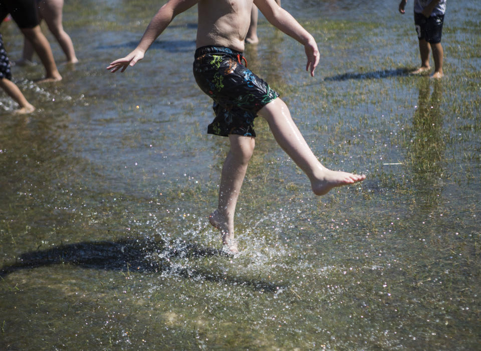 A child kicks water in a large puddle at Walter E. Hall Park on Saturday, June 26, 2021 in Everett, Wa. (Olivia Vanni/The Daily Herald via AP)