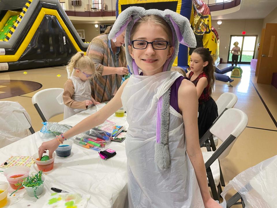 Dressed in her finest bunny ears, Willow Malone, 11, helps the little ones dye eggs at the Easter Eggstravaganza at West Towne Christian Church, April 2, 2023.