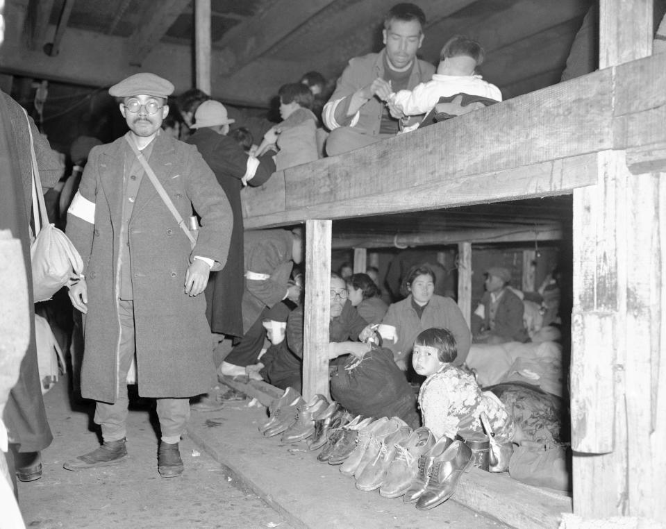 FILE - In this Dec. 16, 1945, file photo, Japanese repatriates, who had led a life of comparative ease in China during World War II, find themselves a bit crowded together in the holds of the S.S. Meiyu Maru, which is carrying them back to Japan from Shanghai. In accordance with Japanese custom of not wearing shoes in their homes, the repatriates remove them before crowding onto their wooden platforms. The bombs stopped falling 75 years ago, but it is entirely possible - crucial even, some argue - to view the region’s world-beating economies, its massive cultural and political reach and its bitter trade, territory and history disputes all through a single prism: Japan’s aggression in the Pacific during World War II. (AP Photo/Frank Filan, File)