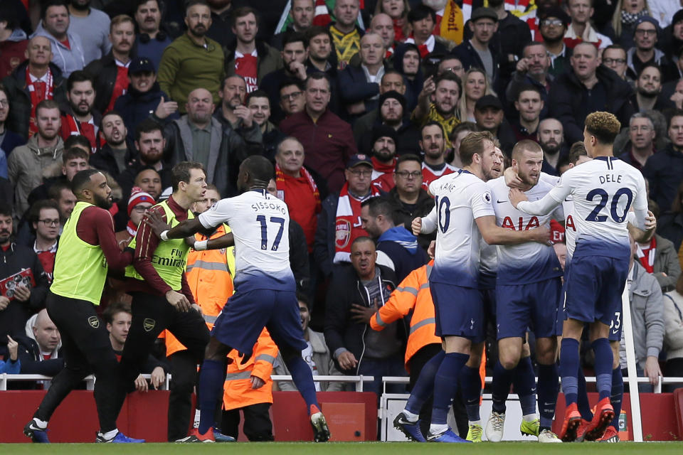 Tottenham's Harry Kane, center, celebrates with his teammates after scoring his side's opening goal from the penalty spot as Tottenham's Moussa Sissoko, third left, agrees with Arsenal's Stephan Lichtsteiner, second left, during the English Premier League soccer match between Arsenal and Tottenham Hotspur at the Emirates Stadium in London, Sunday Dec. 2, 2018. (AP Photo/Tim Ireland)