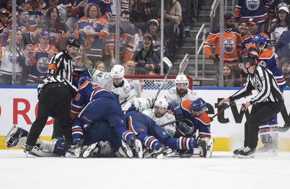 Vancouver Canucks and Edmonton Oilers fall into the net on a loose puck during the first period of Game 3 of an NHL hockey Stanley Cup second-round playoff series in Edmonton, Alberta, Sunday, May 12, 2024. (Jason Franson/The Canadian Press via AP)