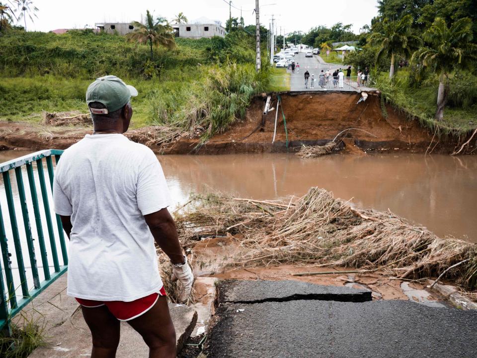 A pedestrian looks at a destroyed bridge after the passage of Fiona storm at the Pont de Goyave, on the French island of Guadeloupe, on September 18, 2022.