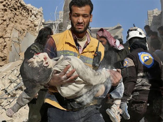 A child is carried from rubble after a barrel bombing on November 24. Photo: AFP
