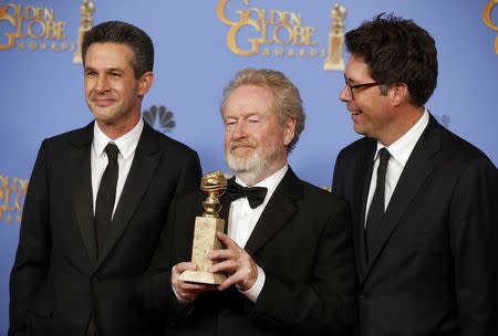 Director Ridley Scott (C), producers Simon Kinberg (L) and Michael Scheafer, pose with the award for Best Motion Picture - Musical or Comedy for "The Martian" during the 73rd Golden Globe Awards in Beverly Hills, California January 10, 2016. REUTERS/Lucy Nicholson