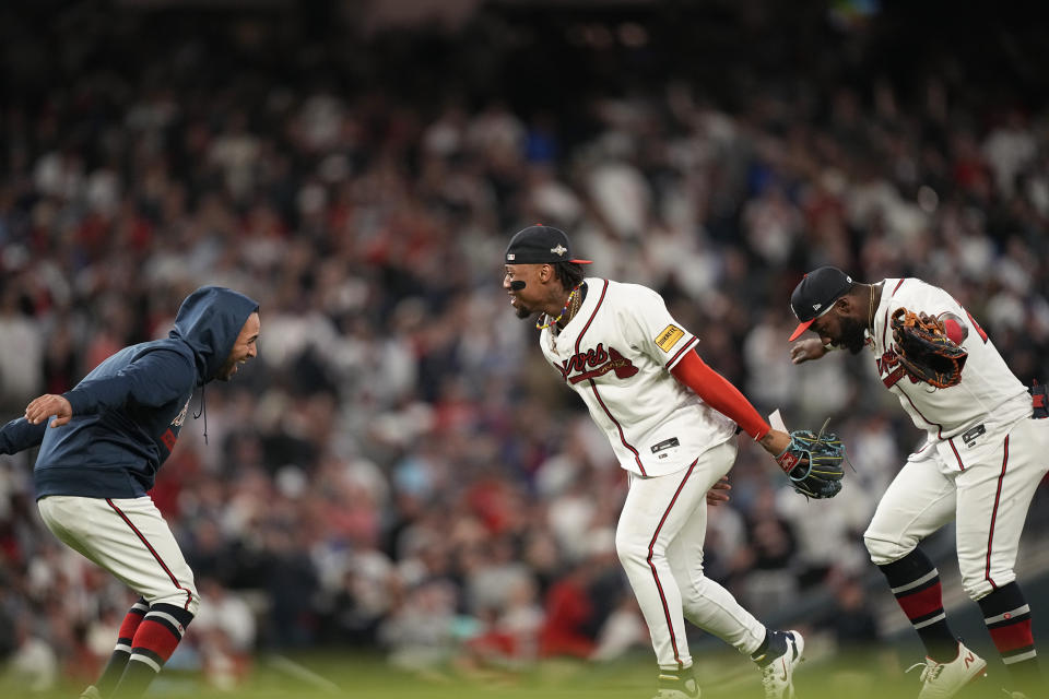 Atlanta Braves' Ronald Acuna Jr., center, celebrates a win with Atlanta Braves' Eddie Rosario, left, after Game 2 of a baseball NL Division Series against the Philadelphia Phillies, Monday, Oct. 9, 2023, in Atlanta. The Atlanta Braves won 5-4. (AP Photo/Brynn Anderson)