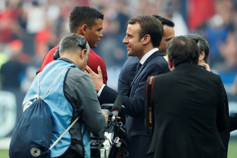 French President Emmanuel Macron (R) shakes hands with Paris Saint-Germain's Thiago Silva (L) prior to the French Cup final on May 27, 2017