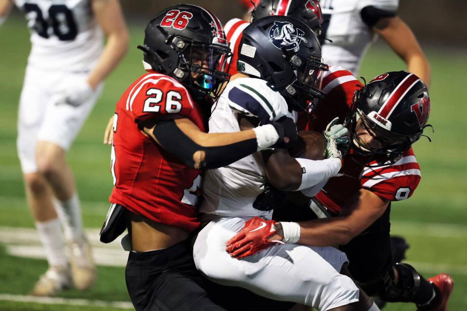 Vista Ridge linebacker Markie Lerma, left, helps tackle a McNeil runner.