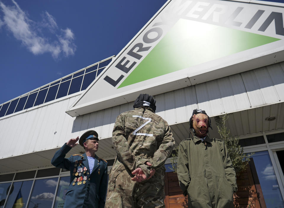 Activists, including Arkadiusz Szczurek, left, take part in a protest outside an outlet of French home improvement retailer Leroy Merlin in Warsaw, Poland, on Saturday May 7, 2022. In the weeks after Russia invaded Ukraine, a protest movement was born in Poland urging people to boycott companies that have chosen to keep operating in Russia. (AP Photo/Pawel Kuczynski)