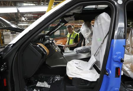 Worker George Baker looks at a build card for a vehicle destined for China at the Jaguar Land Rover facility in Solihull, Britain, January 30, 2017. REUTERS/Darren Staples