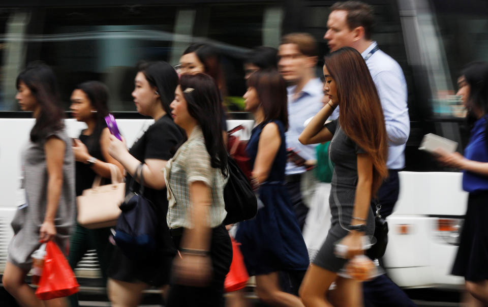 Office workers cross a street in Singapore's central business district April 27, 2017.  REUTERS/Edgar Su