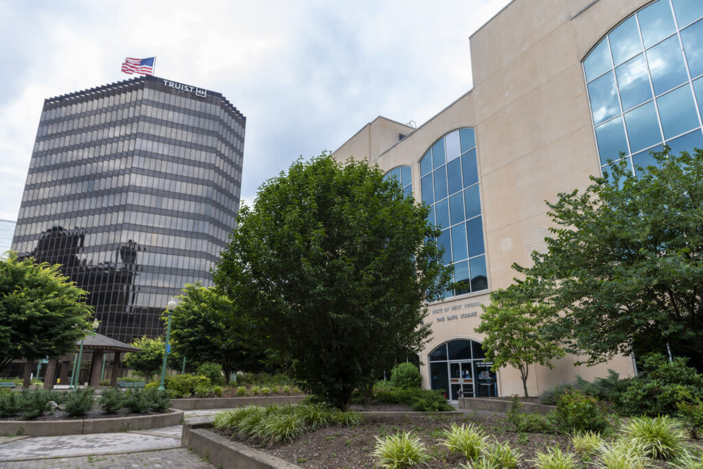 Truist Tower sits next to One Davis Square, with trees and other plants out front.