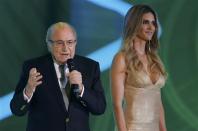 FIFA President Sepp Blatter addresses the audience next to presenter Fernanda Lima during the draw for the 2014 World Cup at the Costa do Sauipe resort in Sao Joao da Mata, Bahia state, December 6, 2013. REUTERS/Paulo Whitaker