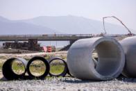 Work crews continue to work on the construction of a freeway overpass in San Diego