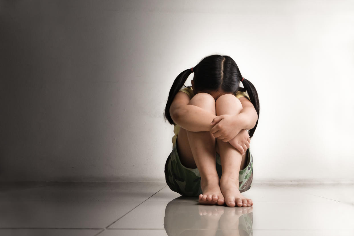 A girl crouched on the floor.