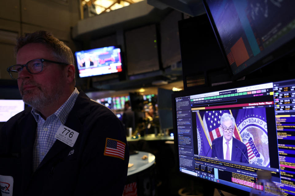 FTSE  A trader works on the floor of the New York Stock Exchange (NYSE) as a screen shows Federal Reserve Board Chairman Jerome Powell during a news conference following a Fed rate announcement, in New York City, U.S., February 1, 2023. REUTERS/Andrew Kelly