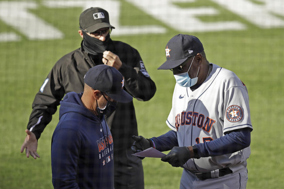 Houston Astros manager Dusty Baker Jr., right, goes over a lineup card with an umpire prior to the baseball game against the Oakland Athletics Friday, Aug. 7, 2020, in Oakland, Calif. (AP Photo/Ben Margot)