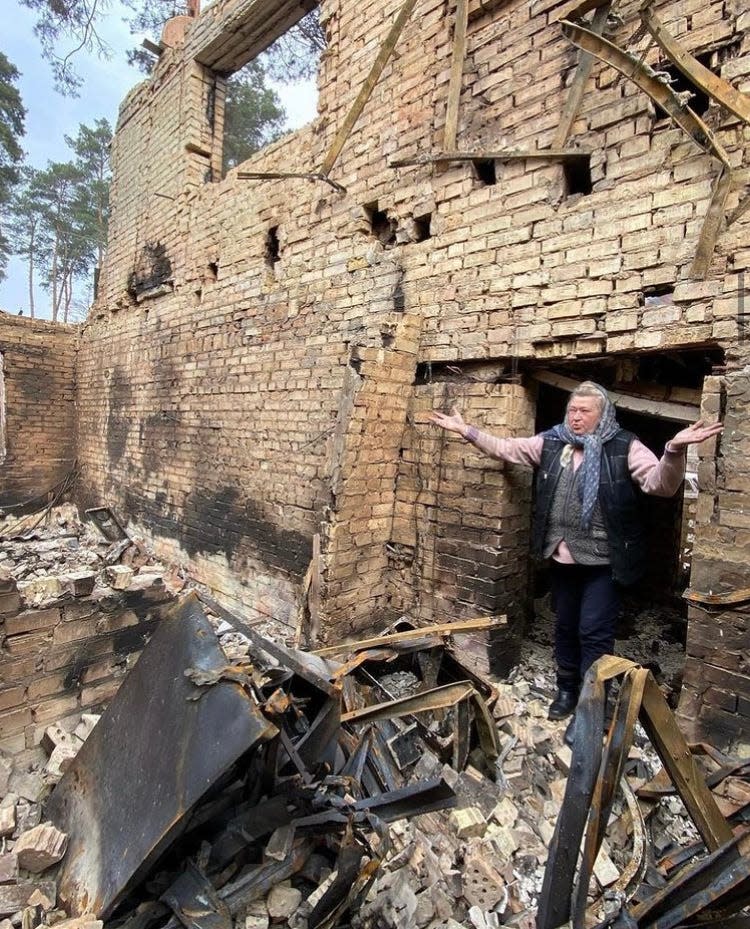 A women stands in the remains of a bombed out building in the Ukrainian city of Bucha in late April 2022.