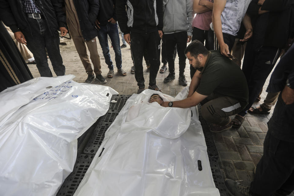 The Chahine family prepares to bury two adults and five boys and girls under the age of 16 after an overnight Israeli strike in Rafah, southern Gaza Strip, Friday, May 3, 2024. An Israeli strike on the city of Rafah on the southern edge of the Gaza Strip killed several people, including children, hospital officials said Friday. (AP Photo/Ismael Abu Dayyah)