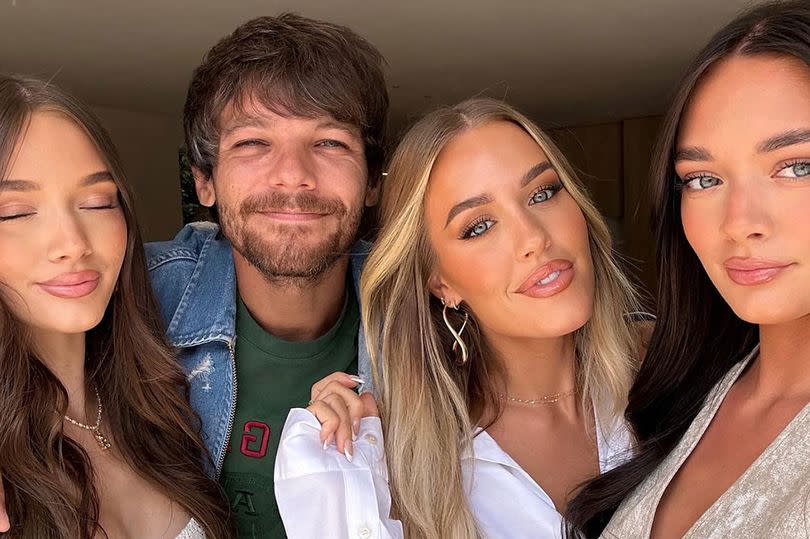 Louis Tomlinson snuggles up to his sisters Phoebe, Lottie and Daisy in a rare family photo.