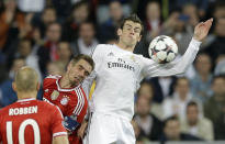 Bayern's Philipp Lahm and Real's Gareth Bale, right, go for a header as Bayern's Arjen Robben, left, looks on during a Champions League semifinal first leg soccer match between Real Madrid and Bayern Munich at the Santiago Bernabeu stadium in Madrid, Spain, Wednesday, April 23, 2014. (AP Photo/Paul White)