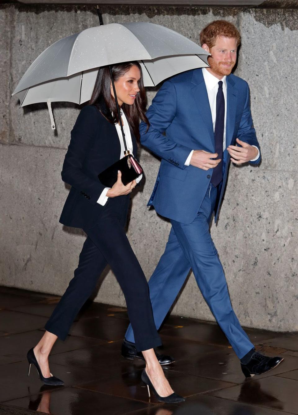 <p>One of our favourite looks to date, Meghan looked incredible in this Alexander McQueen suit, complete with a white pussy-bow blouse and stiletto black pumps. Props to Harry for sacrificing himself in the rain, what a gent. </p>