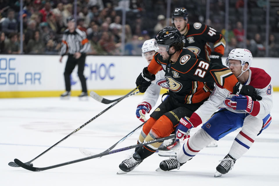 Anaheim Ducks center Mason McTavish (23) and Montreal Canadiens defenseman Mike Matheson (8) vie for the puck during the first period of an NHL hockey game Wednesday, Nov. 22, 2023, in Anaheim, Calif. (AP Photo/Ryan Sun)