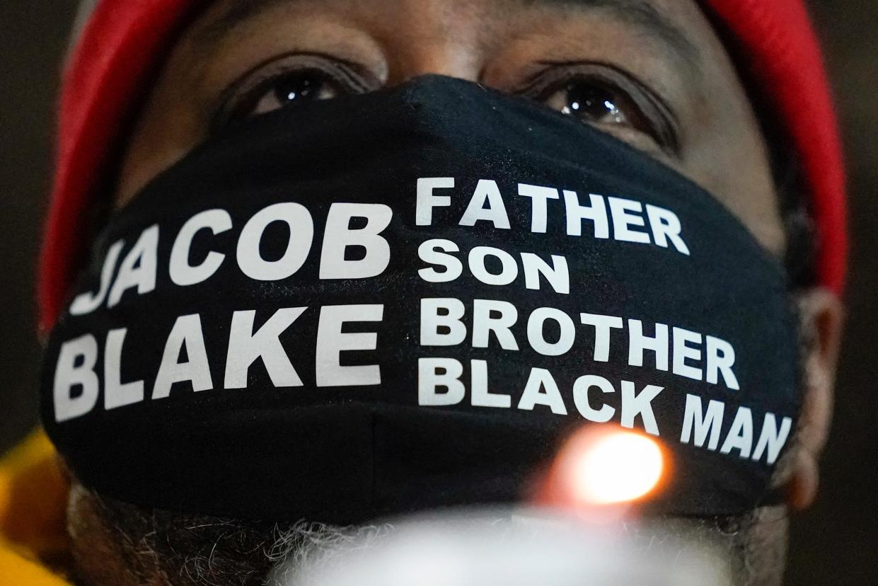 Jacob Blake Sr, father of Jacob Blake, holds a candle at a rally on Monday, 4 January 2021, in Kenosha, Wisconsin (AP)
