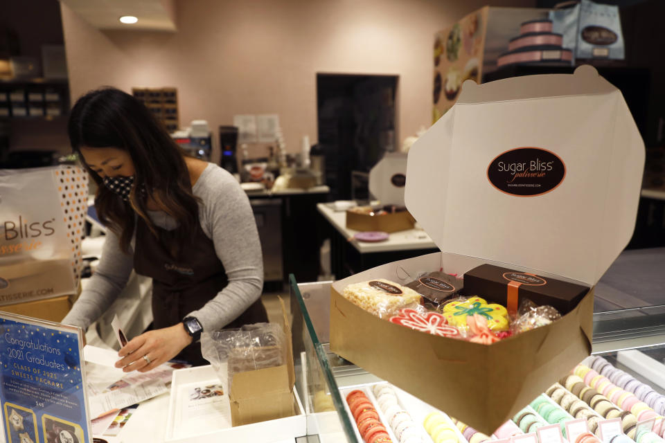Sugar Bliss Bakery owner Teresa Ging prepares for an online order in her shop in Chicago's famed Loop, Tuesday, May 4, 2021. In many downtown areas where companies closed their offices and commuting ground to a halt, sandwich shops, bakeries and other small businesses are waiting with guarded optimism for their customers to return. (AP Photo/Shafkat Anowar)