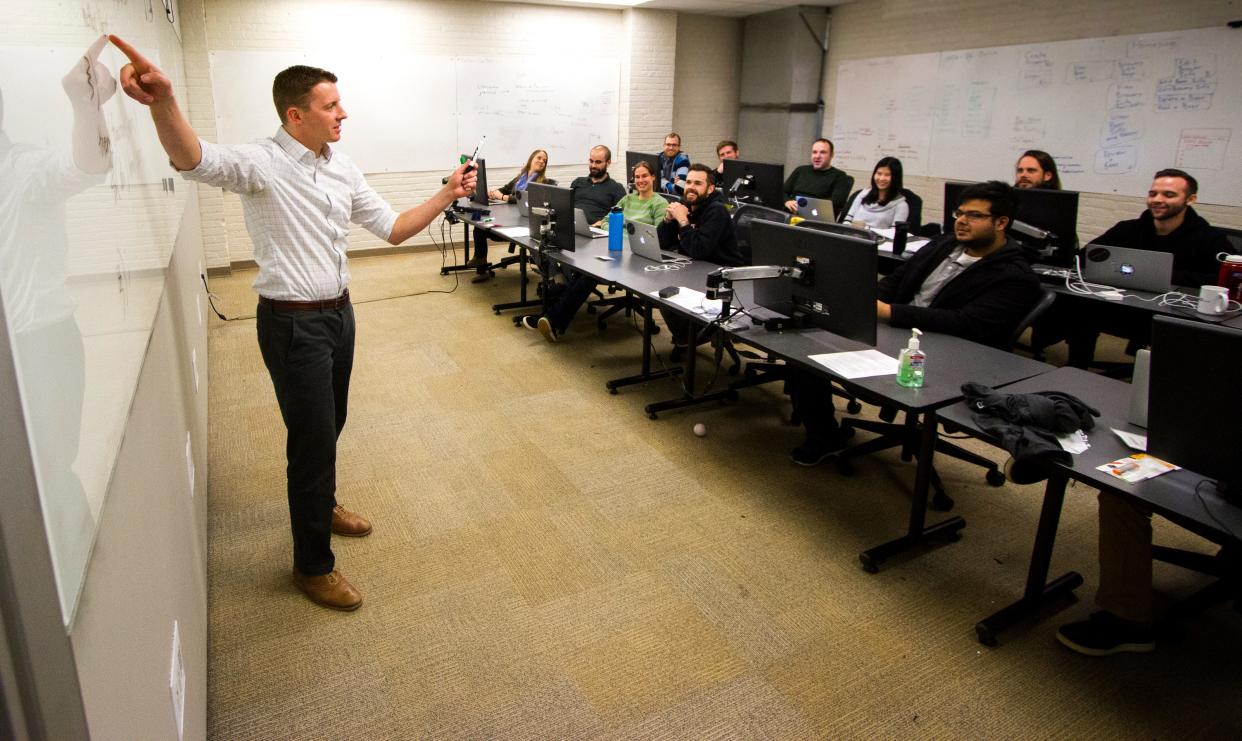 An instructor teaches a cohort of Tech Elevator students. The national program offers a 14-week coding boot camp to help many pursue a career switch to tech.