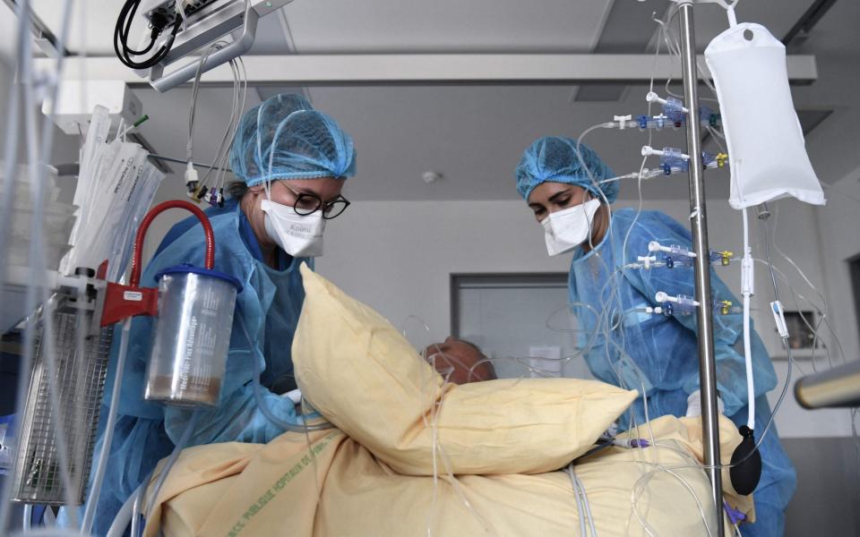 Medical staff members tend to a Covid-19 patient in a room of the intensive care unit of the Henri Mondor Hospital in Creteil, near Paris