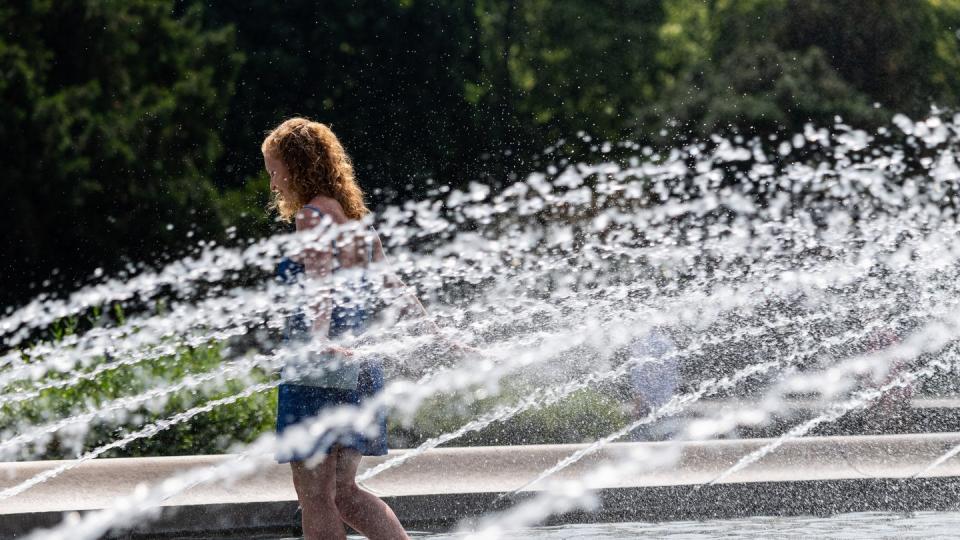 Die junge Frau aus Dresden läuft durch einen Brunnen am Albertplatz um sich abzukühlen. Foto: Robert Michael