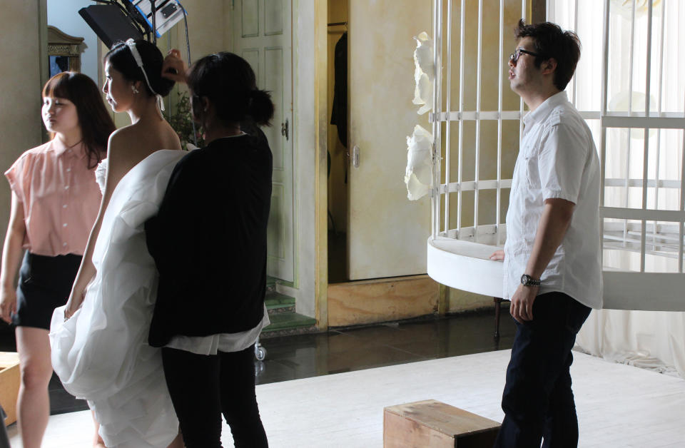 In this Tuesday, July 30, 2013 photo, Yang Candi, second from left, of Beijing, China, listens to her South Korean photographer before taking her position in a stage birdcage during an eight-hour wedding shoot at a wedding studio in southern Seoul, South Korea. China is the source of one quarter of all tourists to South Korea, and a handful of companies in South Korea’s $15 billion wedding industry are wooing an image-conscious slice of the Chinese jet set happy to drop several thousand dollars on a wedding album with a South Korean touch. (AP Photo/ Elizabeth Shim)