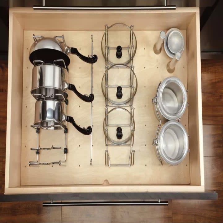 a top down look of an organized kitchen drawer with a peg board bottom