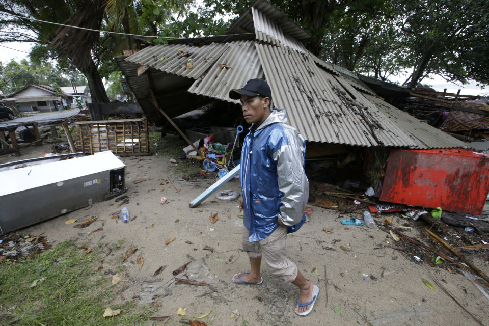 A man inspects his house damaged by a tsunami in Carita, Indonesia, Sunday, Dec. 23, 2018. The tsunami occurred after the eruption of a volcano around Indonesia's Sunda Strait during a busy holiday weekend, sending water crashing ashore and sweeping away hotels, hundreds of houses and people attending a beach concert. (AP Photo/Achmad Ibrahim)