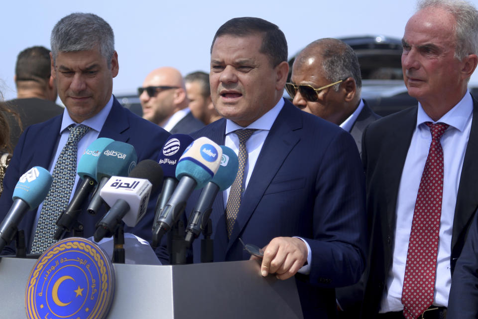 The prime minister of one of Libya's rival administrations, Abdul-Hamid Dbeibah, center, delivers a speech after his arrival in Tripoli, Libya, July 24, 2023, on the first direct flight between Italy and Libya in nearly a decade by a commercial airline. Oil-rich Libya plunged into chaos after a NATO-backed uprising toppled and killed longtime dictator Moammar Gadhafi in 2011. In the disarray that followed, the country split into rival administrations in the east and west, each backed by rogue militias and foreign governments, and much of the country's international air connections were cancelled. (AP Photo/Yousef Murad)