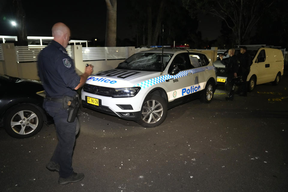 Police officers check vandalized vehicles outside a church where a bishop and churchgoers were reportedly stabbed in Sydney Australia, Monday, April 15, 2024. Police in Australia say a man has been arrested after a bishop and churchgoers were stabbed in the church. There are no life-threatening injuries. (AP Photo/Mark Baker)