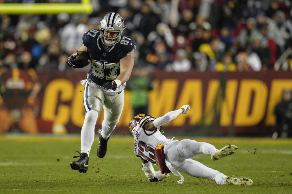 Dallas Cowboys tight end Jake Ferguson (87) carries the ball against Washington Commanders cornerback Emmanuel Forbes (13) during the first half of an NFL football game, Sunday, Jan. 7, 2024, in Landover, Md. (AP Photo/Jessica Rapfogel)