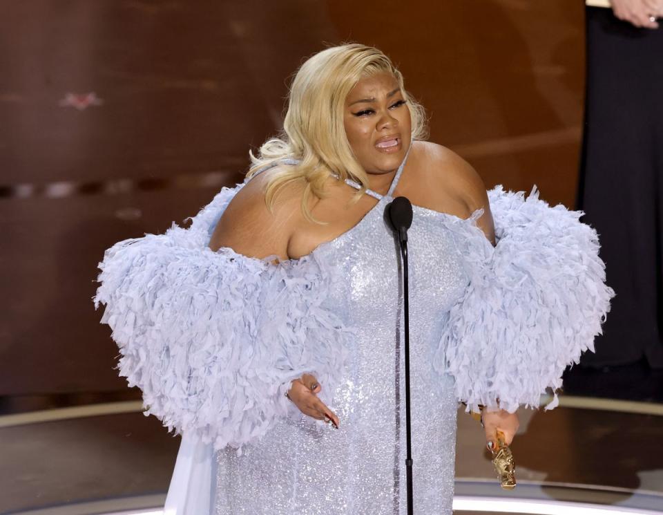 a woman wearing a white dress and holding a microphone